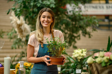 Woman florist taking care of a plant in a flower shop