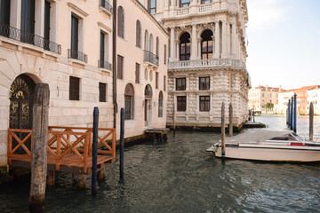 Fototapeta na wymiar Canal in Italian Venice between ancient buildings with boats on it.