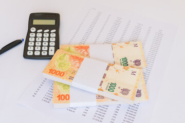 One Thousand Pesos Argentinos Bills Bundles with calculator on financial paper. Money concept