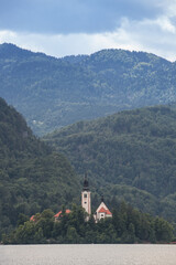 Fototapeta na wymiar Panorama of the Blejsko ostrvo, or bled island, on Bled lake or Blejsko Jezero, with the assumption of Maria church, or cerkev marijinega vnebovzetja. it's a catholic church and monument of Slovenia