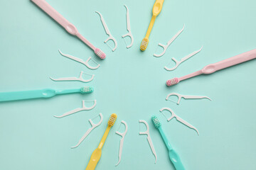 Frame made of toothbrushes and floss toothpicks on color background
