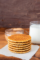 Traditional local authentic Dutch Netherlands sweet fresh homemade tasty stack brown golden waffle melt salted caramel honey syrup for dessert in cafe with hot warm coffee milk tea call Stroopwafel