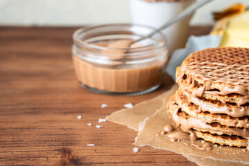 Traditional local authentic Dutch Netherlands sweet fresh homemade tasty stack brown golden waffle melt salted caramel honey syrup for dessert in cafe with hot warm coffee milk tea call Stroopwafel