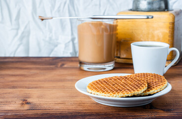 Traditional local authentic Dutch Netherlands sweet fresh homemade tasty stack brown golden waffle melt salted caramel honey syrup for dessert in cafe with hot warm coffee milk tea call Stroopwafel