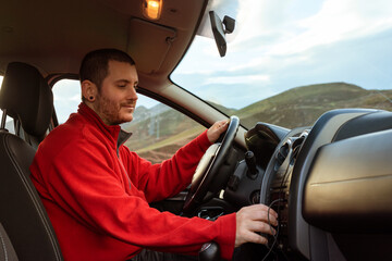 Fototapeta na wymiar young man tuning into his car radio during a trip.