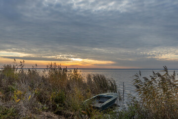 Obraz premium Colorful sunrise on the shores of Lake Nero. Autumn landscape with a lake in the early morning. A bright streak of light on the horizon, dawn.