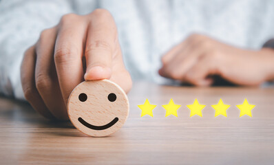 Business woman hand holding smiley face emoticon on virtual touch screen.good feedback rating and positive customer review, experience, satisfaction survey, world mental health day concept