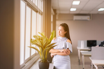 Beautiful business asian woman standing and looking on window in the office