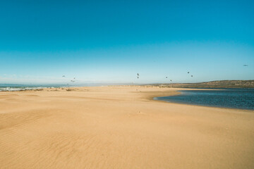 Where the river merges with the ocean. California beach landsape, blue sky background