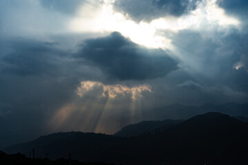 Sunlight through blanket of clouds in mountain 