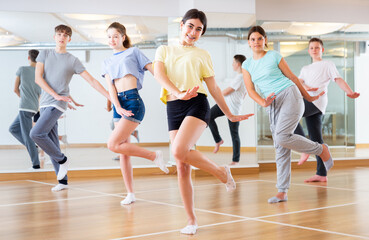 Fototapeta na wymiar Dancing group of five teenagers practicing new dance in studio