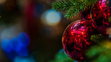 Shiny reflective red Christmas tree ornaments on right with copy space on the left