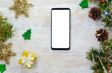 Fototapeta na wymiar technology cell phone on christmas decoration table top view flat lay, mock up for copy space text, smart phone white screen for design, new year online concept no people.