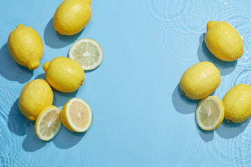 Lemon and sliced lemon in blue background with water wave and water drop , top view , for food advertising