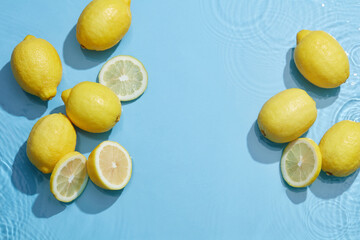 Lemon and sliced lemon in blue background with water wave and water drop , top view , for food...