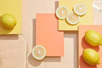 Lemon and sliced lemon in color background with water wave and water drop orange and yellow square podium , top view , blank space for food advertising