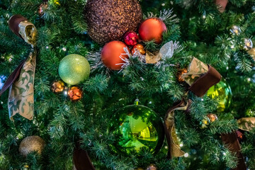 Obraz na płótnie Canvas Christmas tree with green, brown and orange ball ornaments