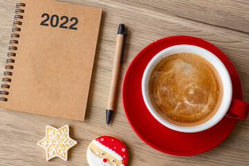 2022 GOAL with notebook, coffee cup, Christmas cookies and pen on wood table. Xmas, Happy New Year, Resolution, To do list, Strategy and Plan concept