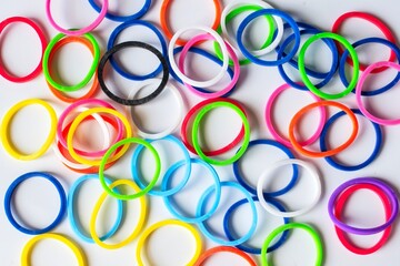 A variety of bright colored rubber bands on a white background.