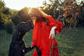 cute woman in red dress playing with dog outdoors friendship