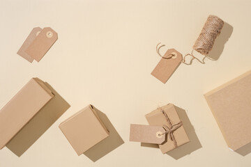 Handmade gift boxes from craft paper with tags on beige background. Eco friendly holiday concept.