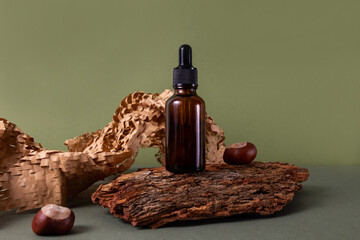 Brown glass bottle of cosmetic product or oil on wood and paper on green background. Natura Spa...