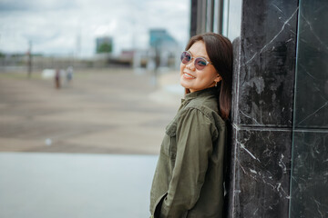 Obraz premium Young Beautiful Asian Woman Wearing Jacket And Black Jeans Posing Outdoors
