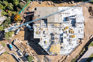 new multi-story building under construction. construction workers pouring wet concrete into floor...