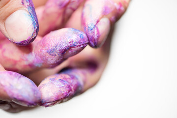 Close up of artists hands with fingers covered in purple and blue paint`