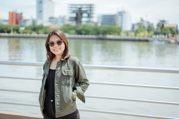 Young Beautiful Asian Woman Wearing Jacket And Black Jeans Posing Outdoors