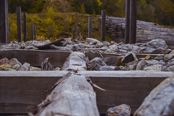 wooden cells of logs covered with stones