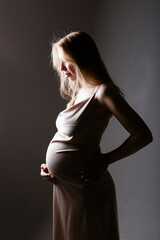Fototapeta premium caucasian pregnant woman stroking her belly on white background. Copy space. The concept of healthy digestion, lifestyle, IVF