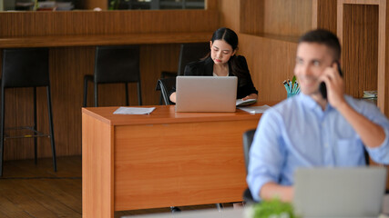 Female accountant focused on financial information reports via laptop