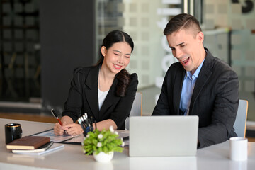 Two of businesspeople happy and excited after looking business sale profit report