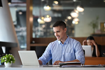 Fototapeta premium Handsome businessman working with laptop computer in modern office.