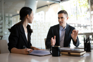 Two confident business people discussing for new project planning in modern office.