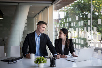 Two businesspeople analyzing and discussing online data on laptop.computer.