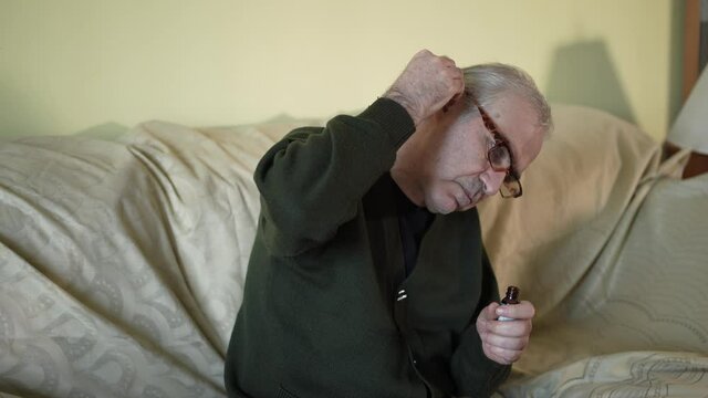Senior Elderly Men Using Ear Drops For His Hearing Problems