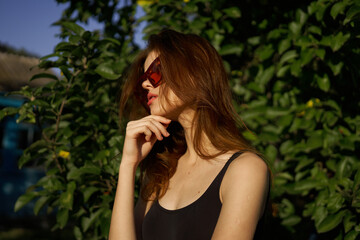 fashionable woman in sunglasses and green leaves summer exotic