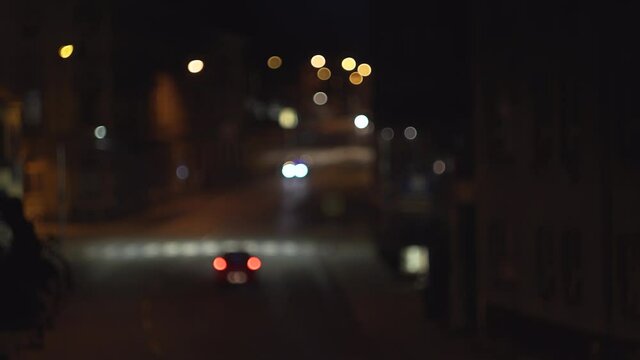 Blurry lights of cars traffic in city at night, low aperture, calm stable view