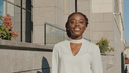Moving filming successful happy carefree afro american girl joyful african business woman female student lady boss tourist walking modern city street outdoors walk going move inside at summer day