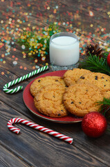traditional Christmas drink eggnog cocktail and homemade chocolate cookies, a glass of fresh milk and sweets for santa, tradition on merry christmas Eve