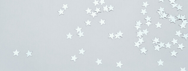 Silver stars confetti on gray banner. Christmas or winter festive background