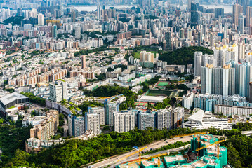 Naklejka premium Panorama aerial view of Hong Kong Kowloon's crowded buildings and Victoria Harbour in China.