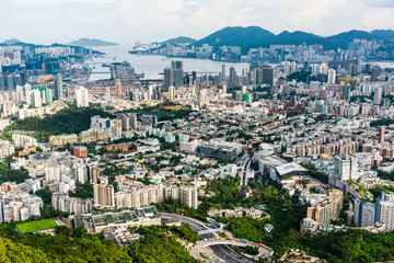 Fototapeta na wymiar Panorama aerial view of Hong Kong Kowloon's crowded buildings and Victoria Harbour in China.