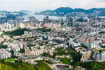 Fototapeta premium Panorama aerial view of Hong Kong Kowloon's crowded buildings and Victoria Harbour in China.