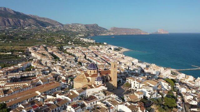 Panoramic aerial view of Altea city by Mediterranean coast overlooking blue and white domes of Church of Our Lady of Solace, Spain