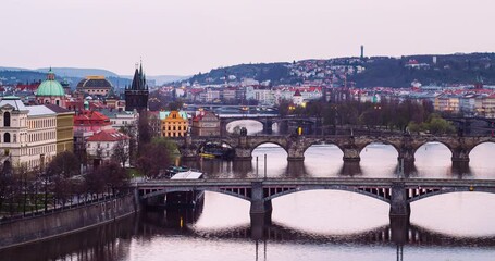 Timelapse of starting night in Prague, Czech Republic, lighting on street lamps, bridges over Vltava river view