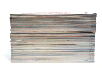 Stack of magazines and newspapers on a white background.