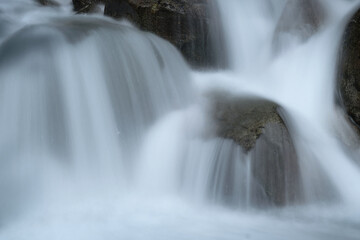 Wild mountain river in the mountains. Long exposure waterfall. Mountain river in the Alps long exposure. Flowing water over rocks, motion blur. Cold, clear water in the Italian Alps.